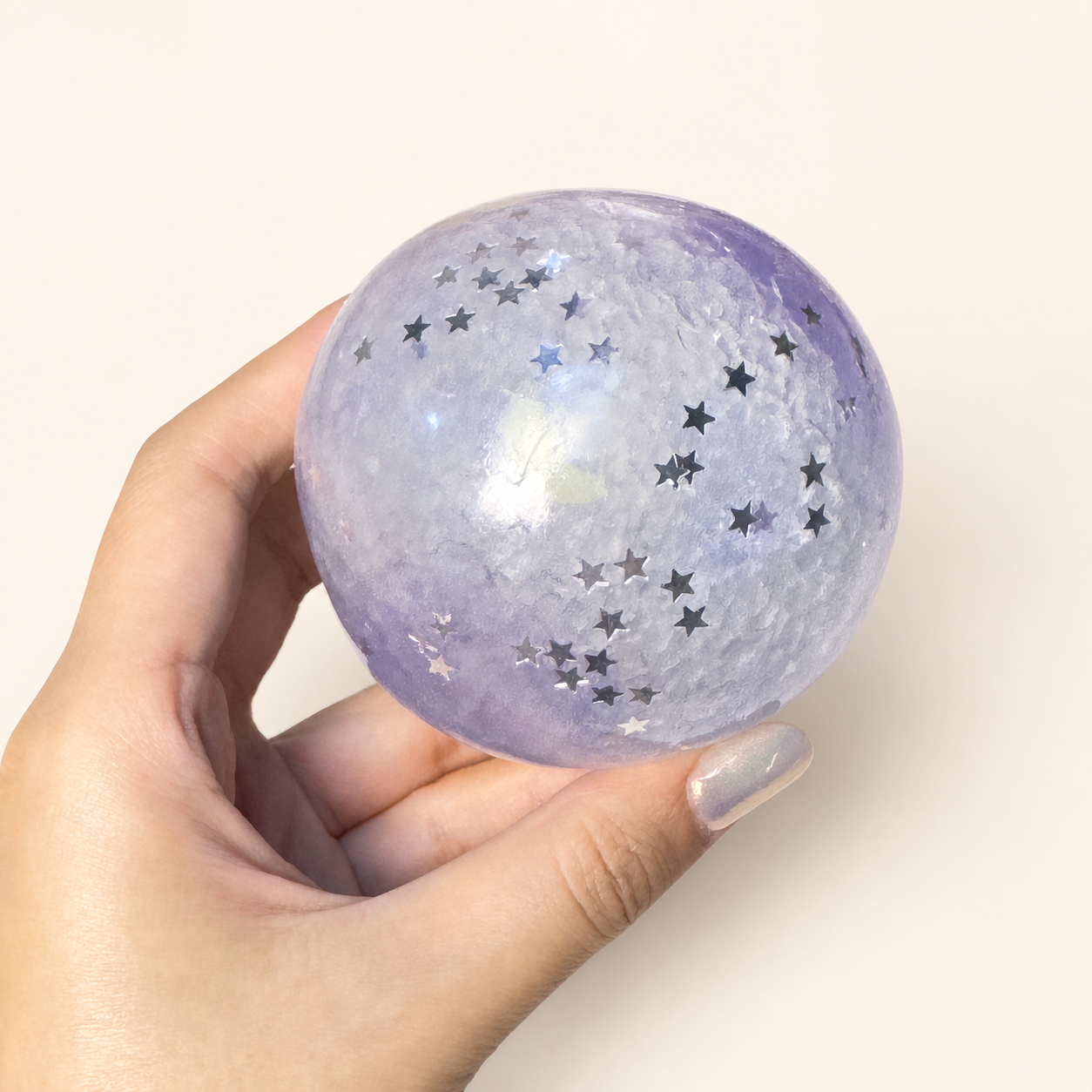 Hand holding the lavender Purple Mist Stardust Slush Sensory Ball