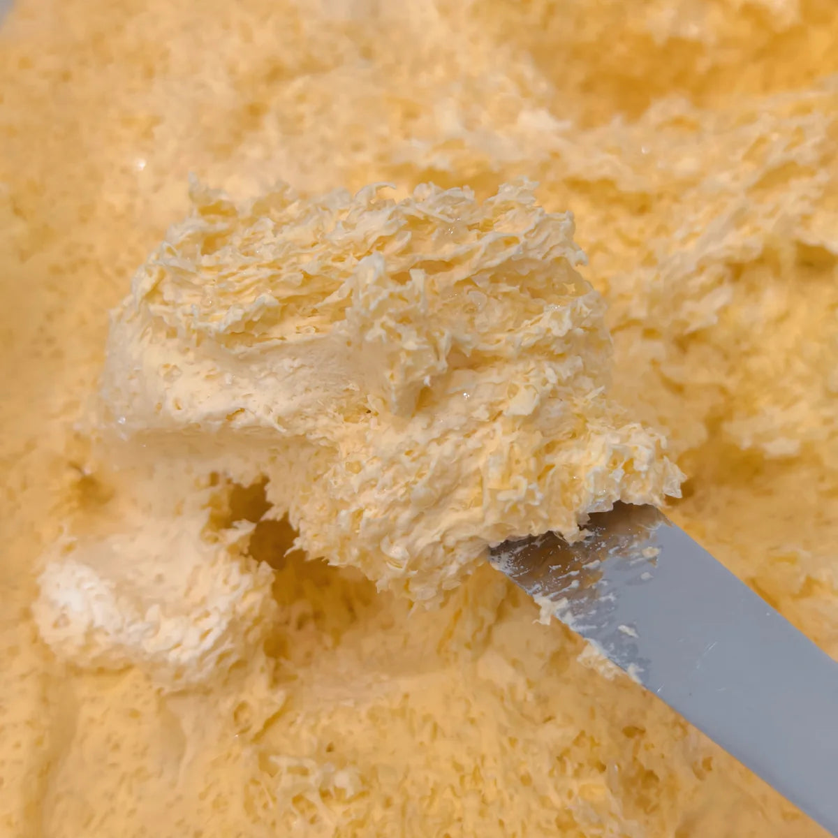 Close-up of ZENGUE yellow tactile material with layered flakes